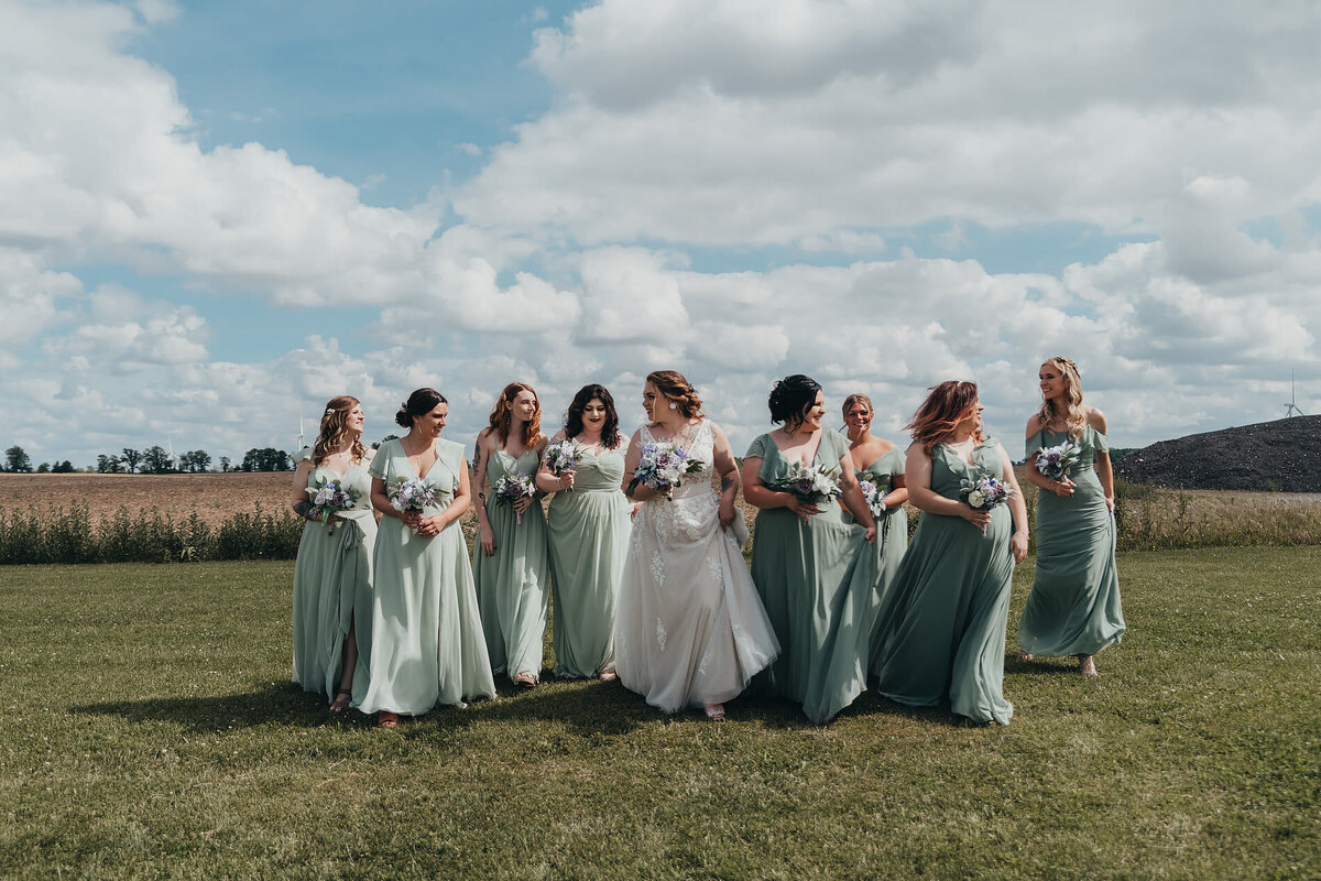 large bridal party walking in field