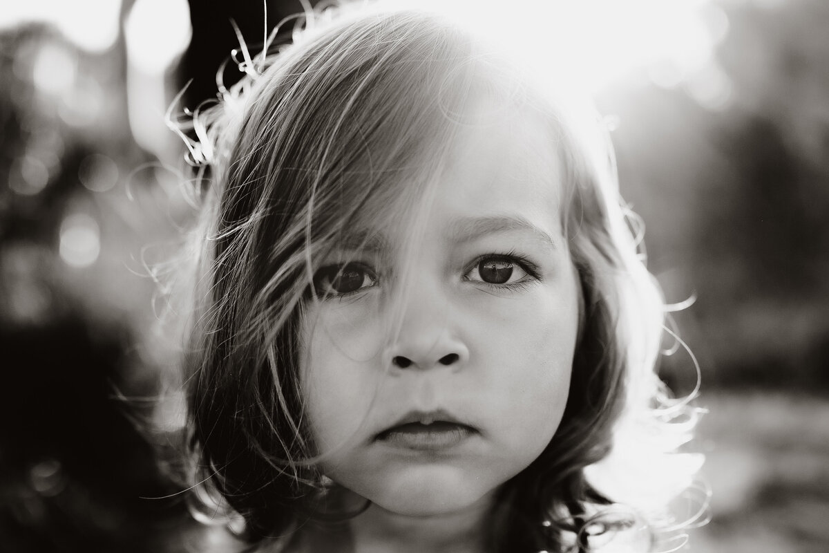stunning up close black and white portrait of a toddler looking seriously at the camera