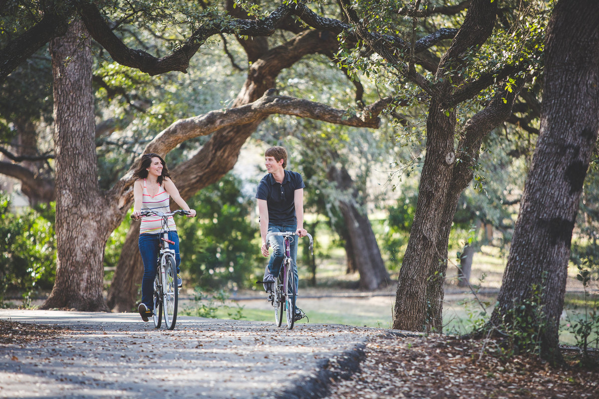 Man and woman riding their bike on their engagement session at Denman Estate Park.
