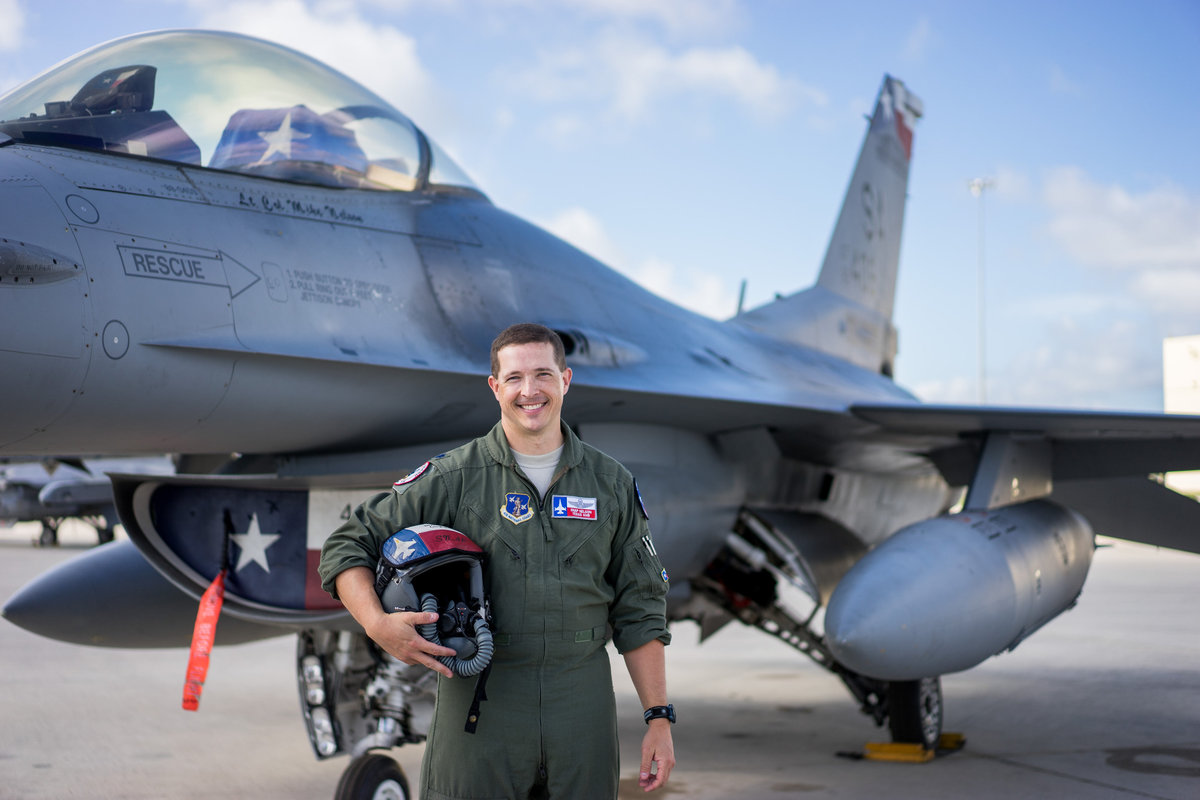 Air Force pilot standing in front of his jet that has a Texas flag painted on it on a military base in San Antonio.