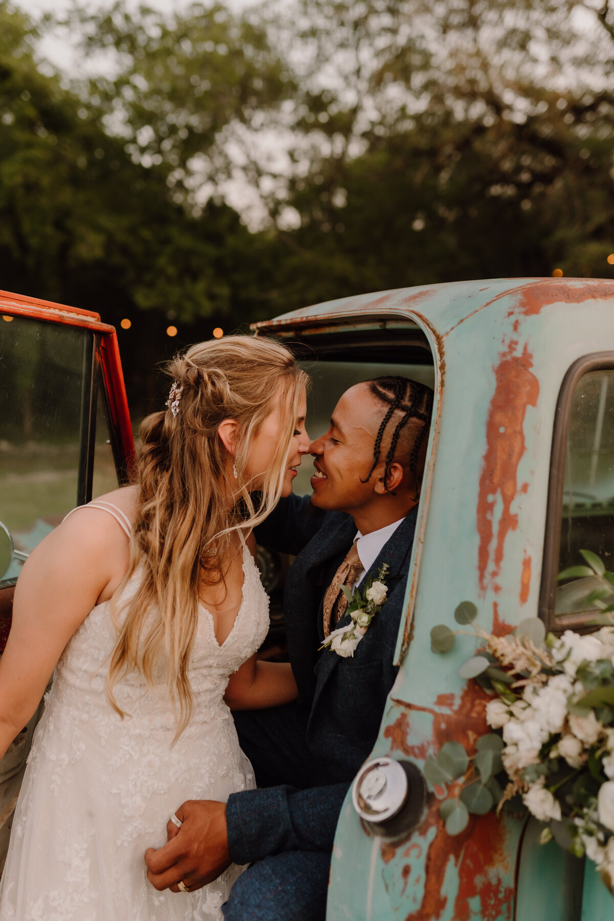 bride and groom kissing in truck
