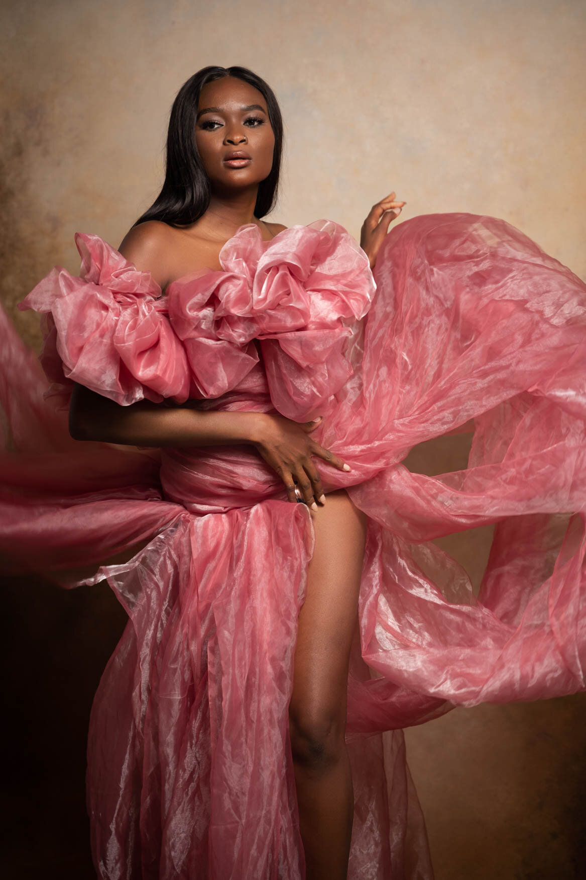 Black woman with long hair wearing a pink tulle gown