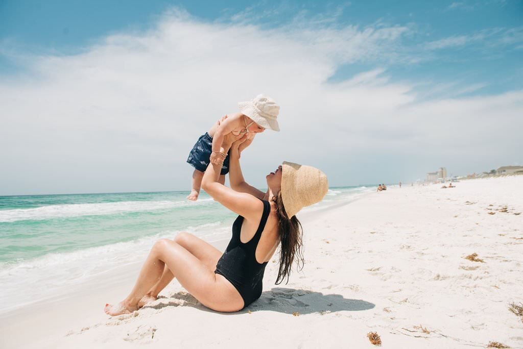 mom holding baby in air at Pensacola Beach