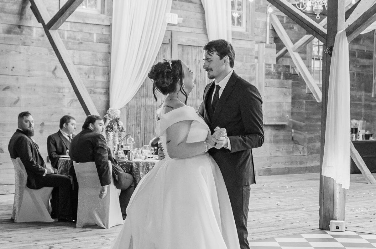 A loving bride and groom dancing during their wedding reception at The Peanut Warehouse enjoying their Raleigh wedding photography session by JoLynn Photography