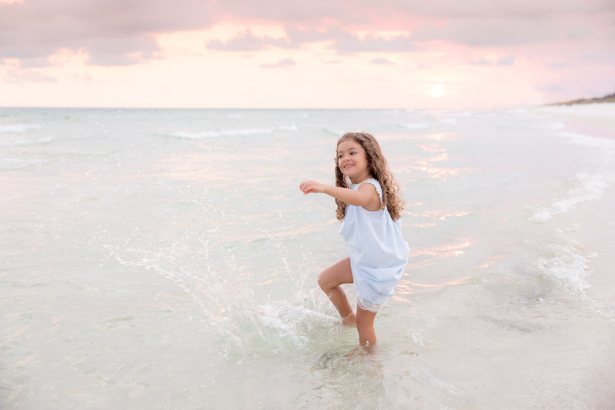 A small girl playing in the waves