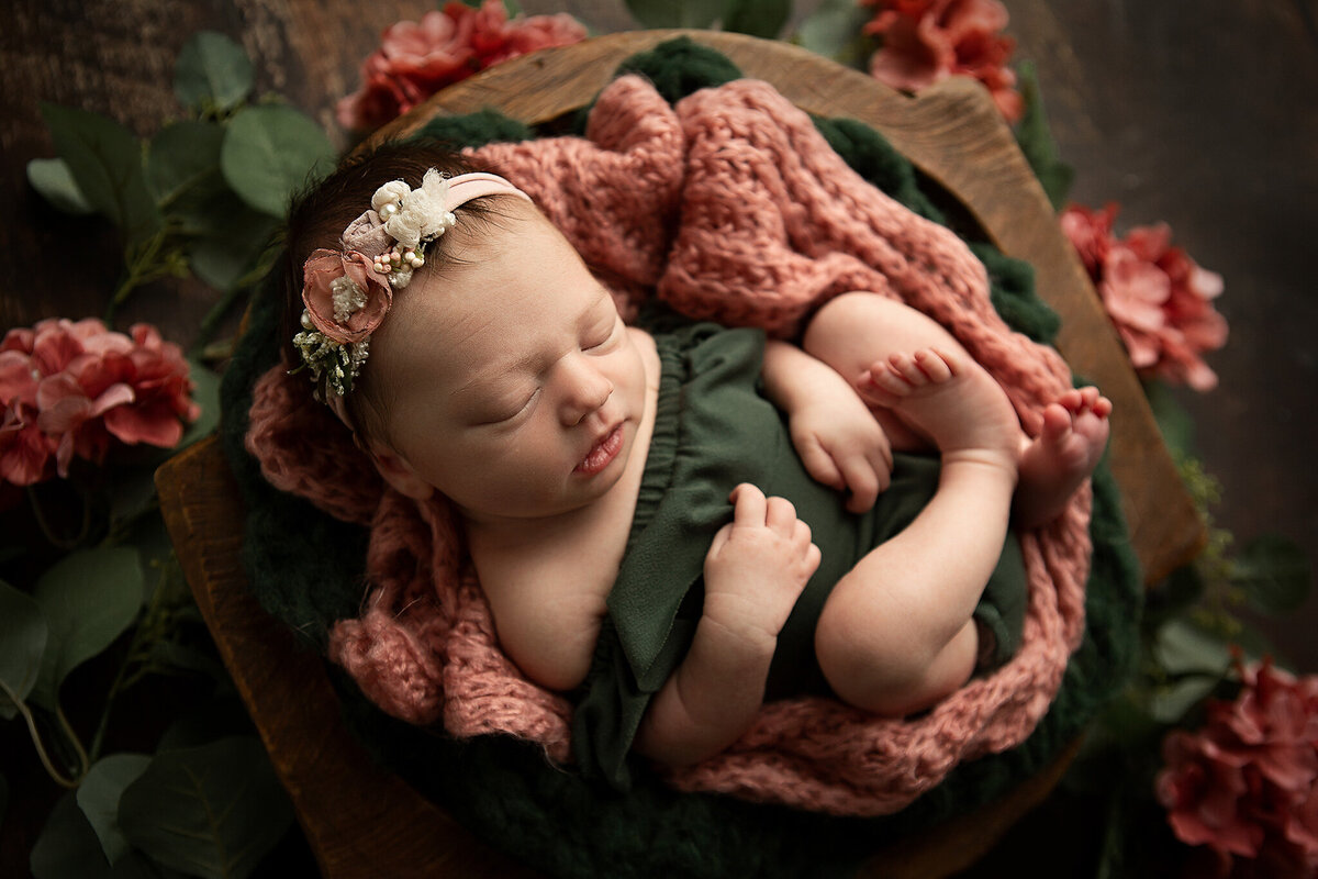 best-dayton-ohio-newborn-photographer-baby-girl-in-dark-green-ruffle-onsie-with-dusty-pink-flowers