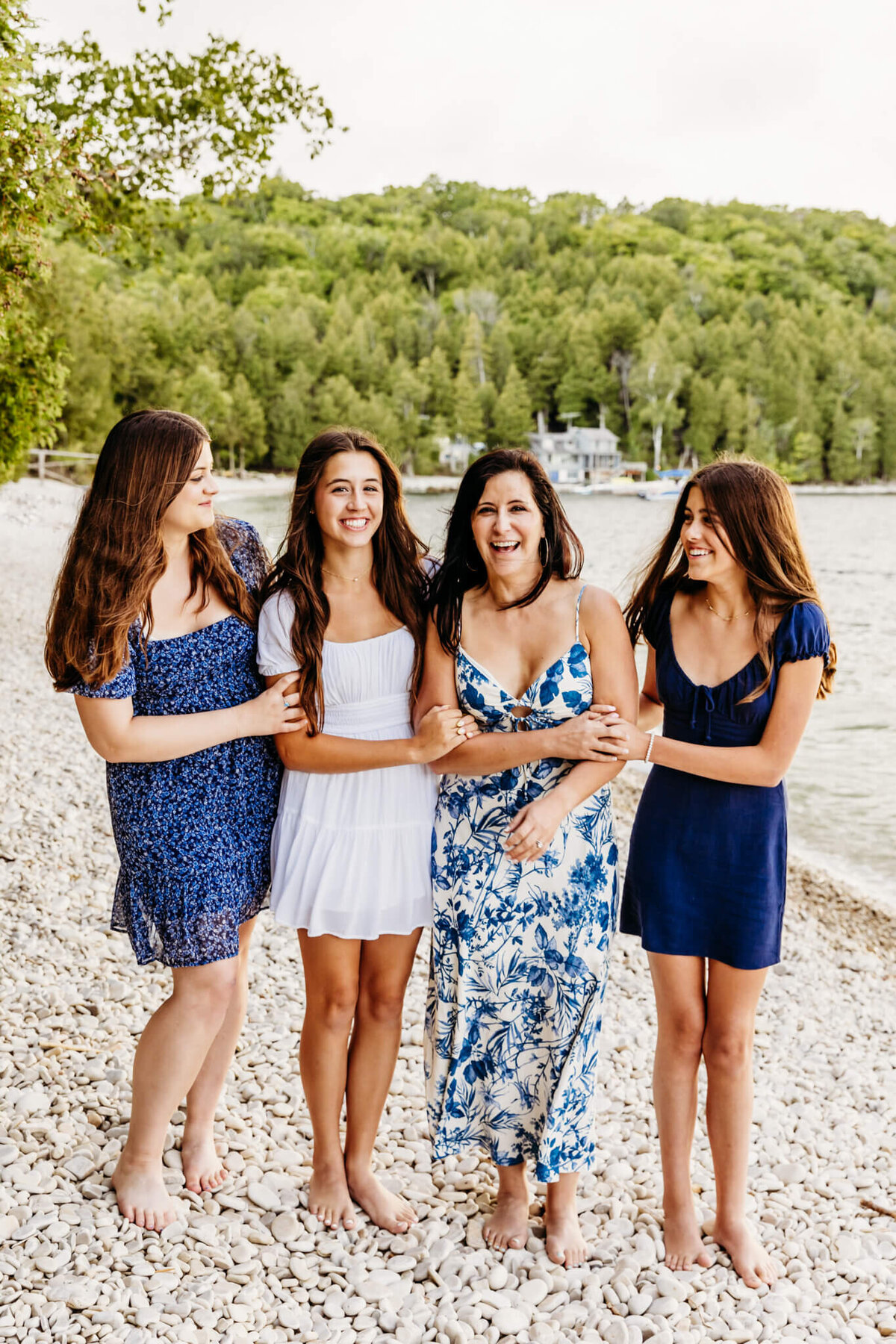mom and 3 daughters enjoying a moment of laughter on a gorgeous beach captured by milwaukee family photographer Ashley Kalbus