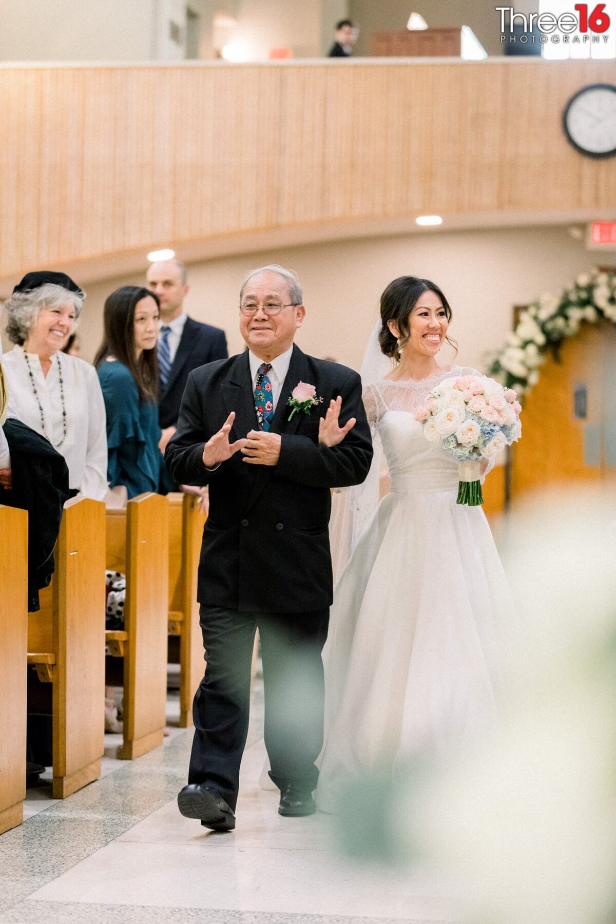 Bride is escorted down the aisle by her father
