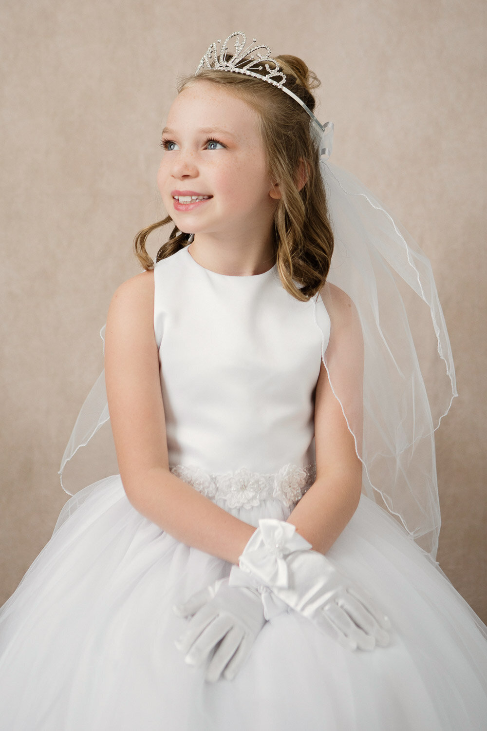 Professional little beauty portrait of girl in white dress and tiara