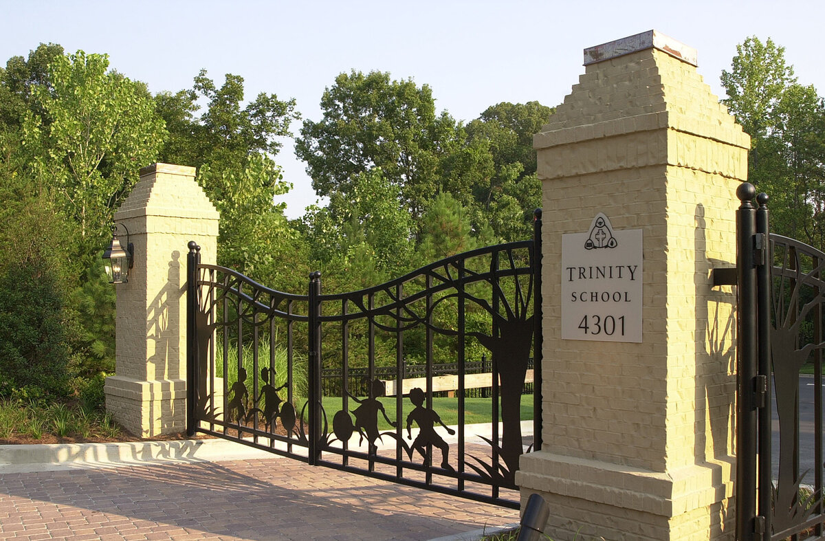 view of the entry gate at Trinity School with brick piers and steel profiles of children