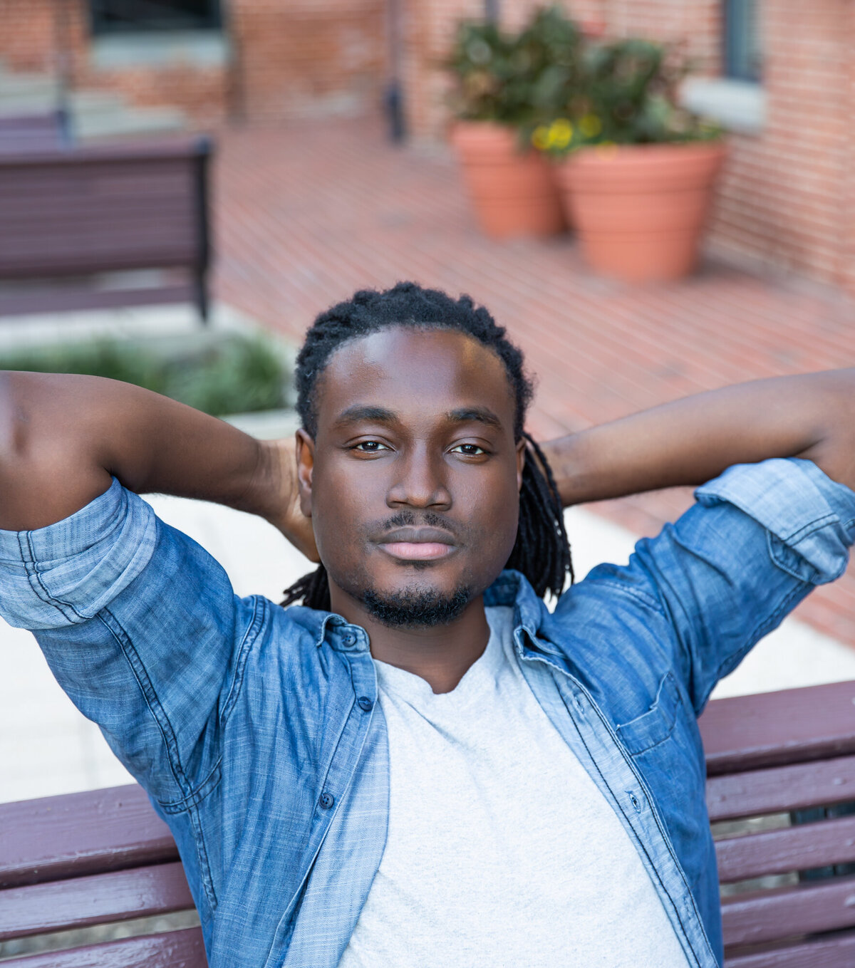 A-business-owner-relaxes-in-a-chill-pose-with-arms-behind-his-head-during-his-branding-photoshoot-in-Baltimore-Maryland