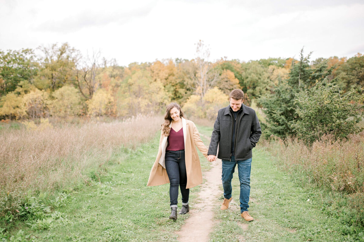 Engaged couple walking down path captured by Niagara wedding photographer Kristine Marie