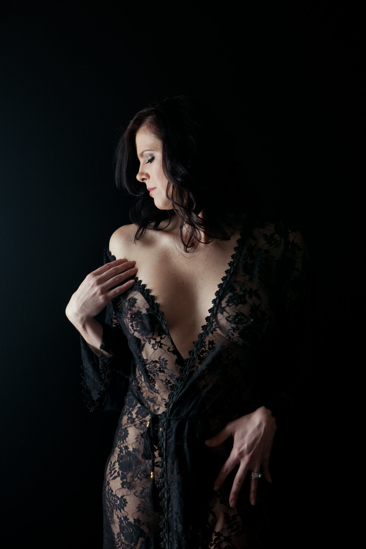 image taken in a New York City Photography Studio by a boudoir photographer. beautiful woman in a black lace robe on a black background