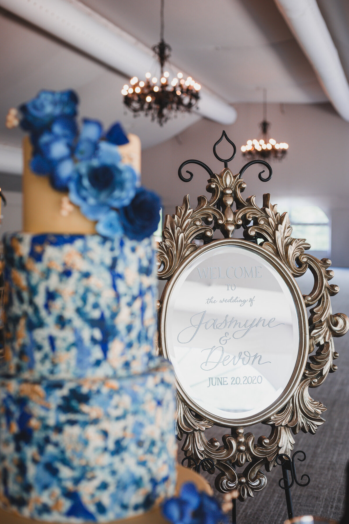 Wedding cake with blue floral details and small round mirror with wedding details