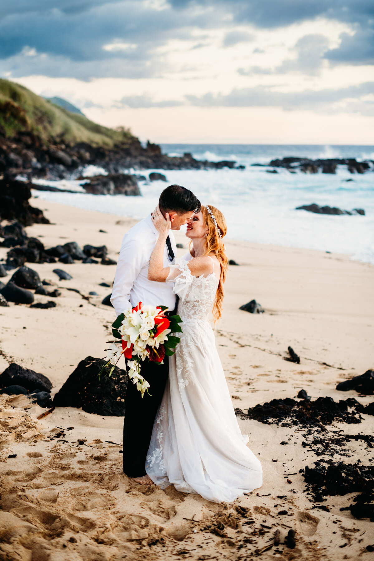 Bride and groom going in for a kiss on the beach