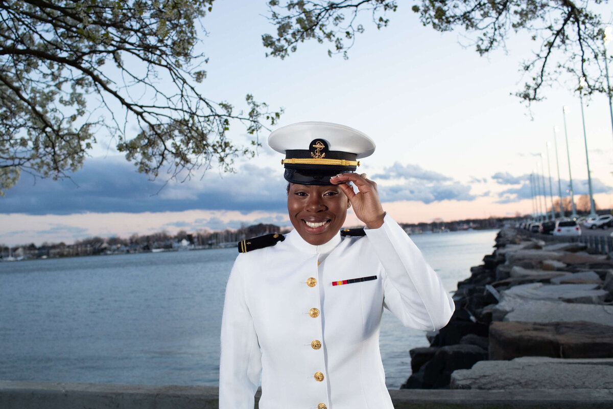 Beautiful Midshipman tips hat by sunset on the water in Annapolis.