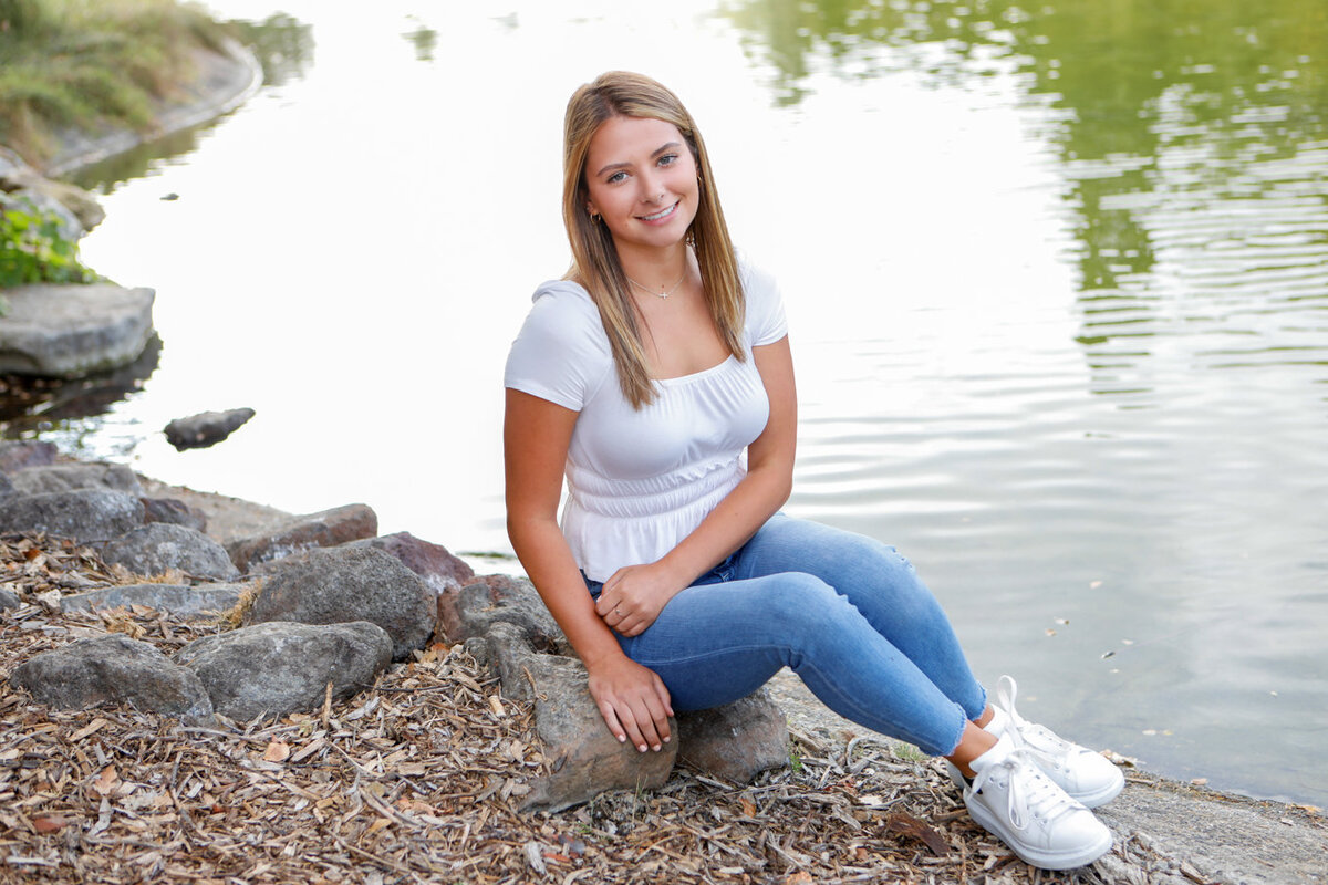 Portrait of senior girl in front of lake, natural light