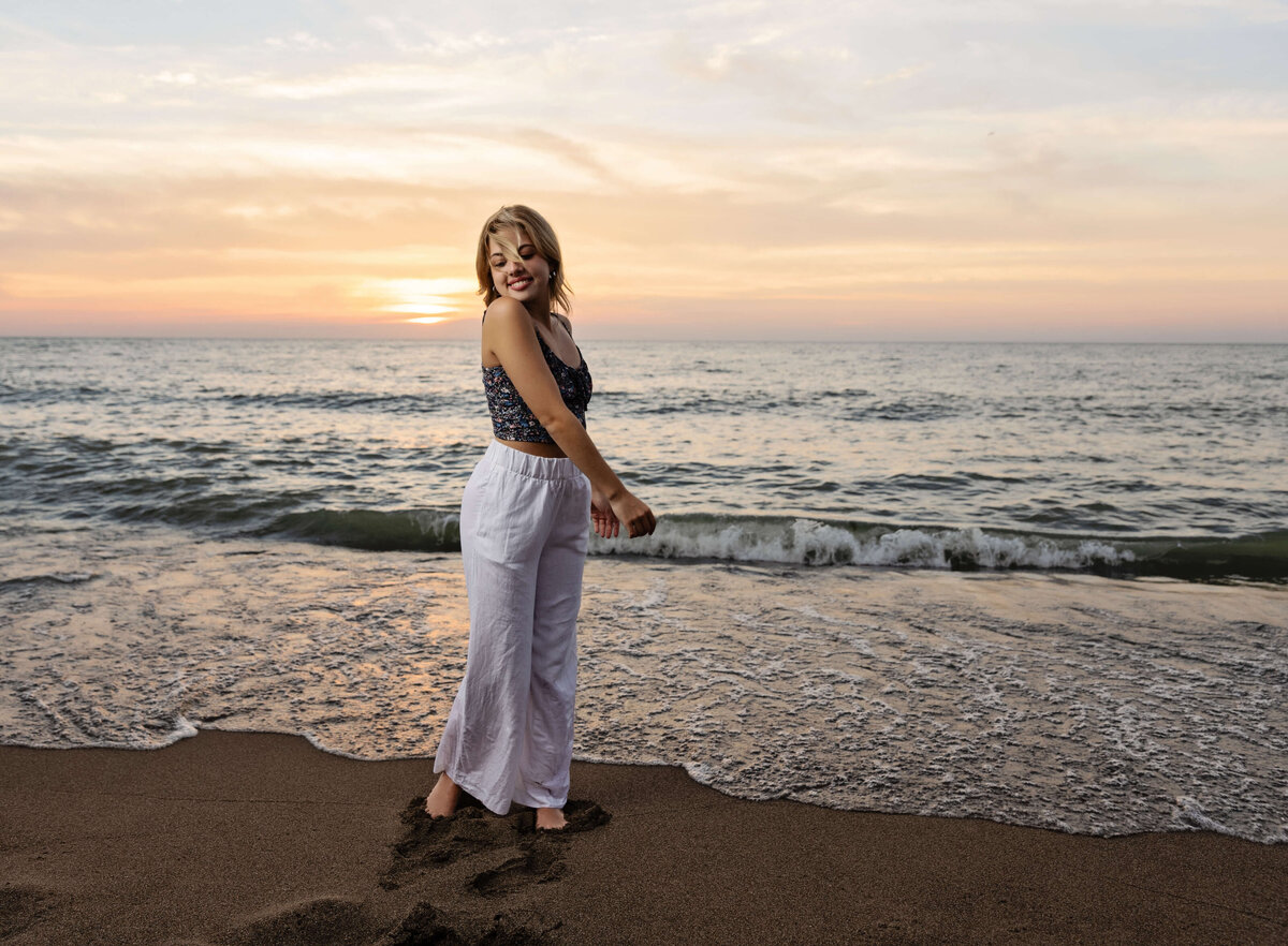 Erie Pa senior girl standing on the shore of Lake Erie at sunset