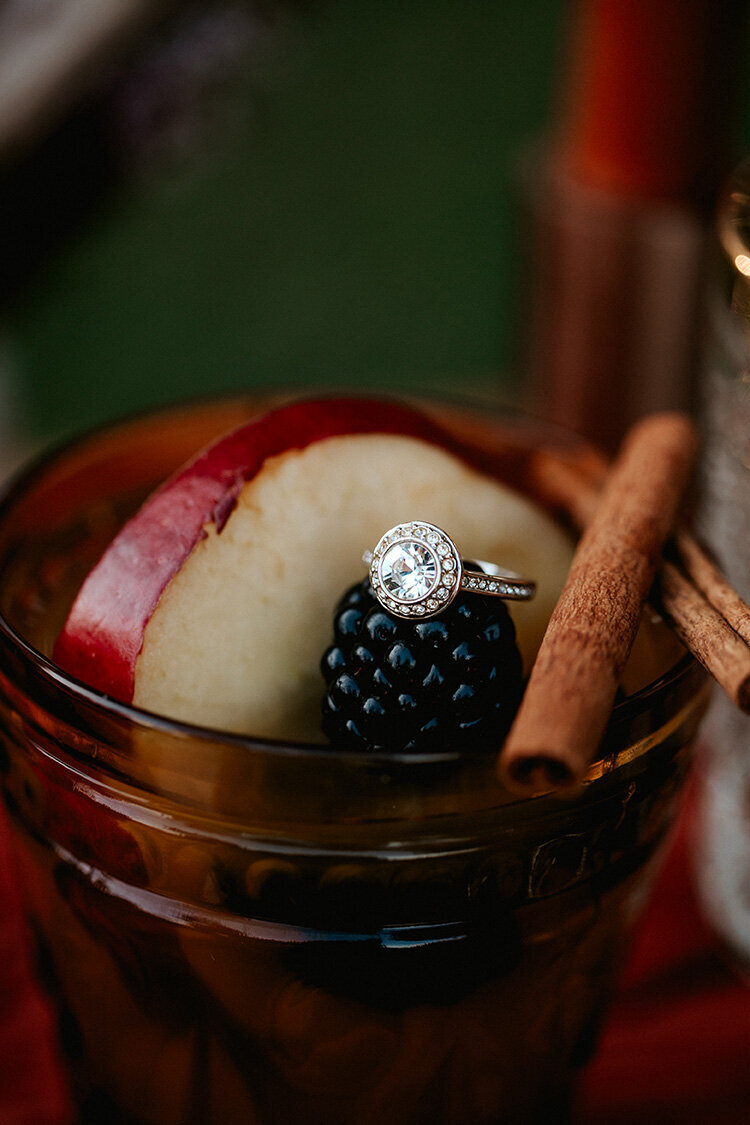 fruit displayed in a yellow stained glass cup with engagement ring atop
