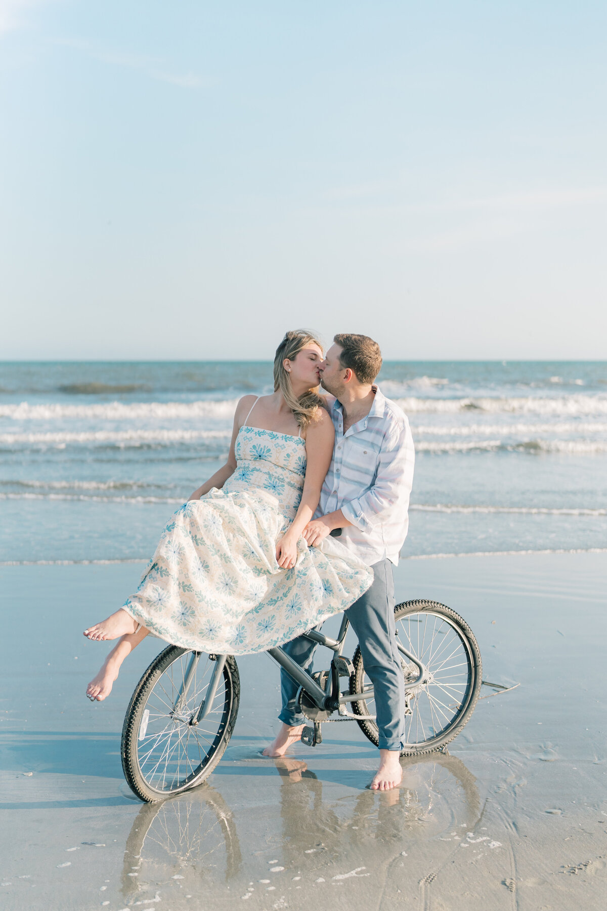 Engagement session on the beach with girl riding on guys handle bars. Fun engagement photos on Kiawah Beach. Kailee DiMeglio photography.