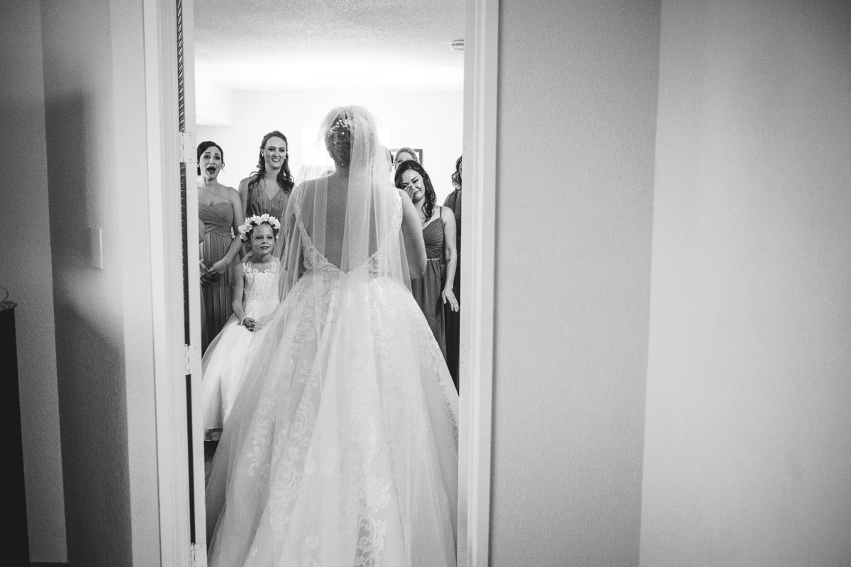 Bride Stands in the Doorway as Her Bridal Party Looks on Before Her Tampa Bay Florida Wedding