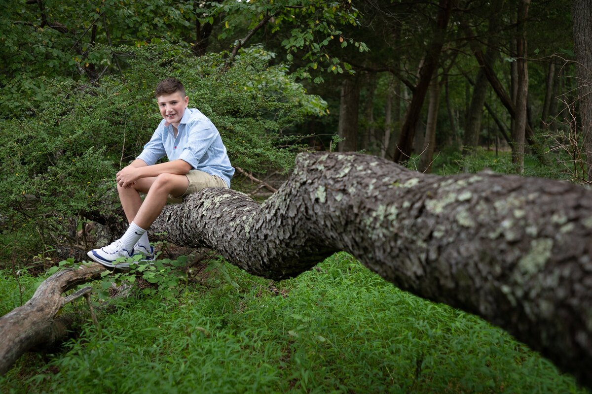bar-mitzvah-preshoot-boy-sitting-on-branch-allaire-park