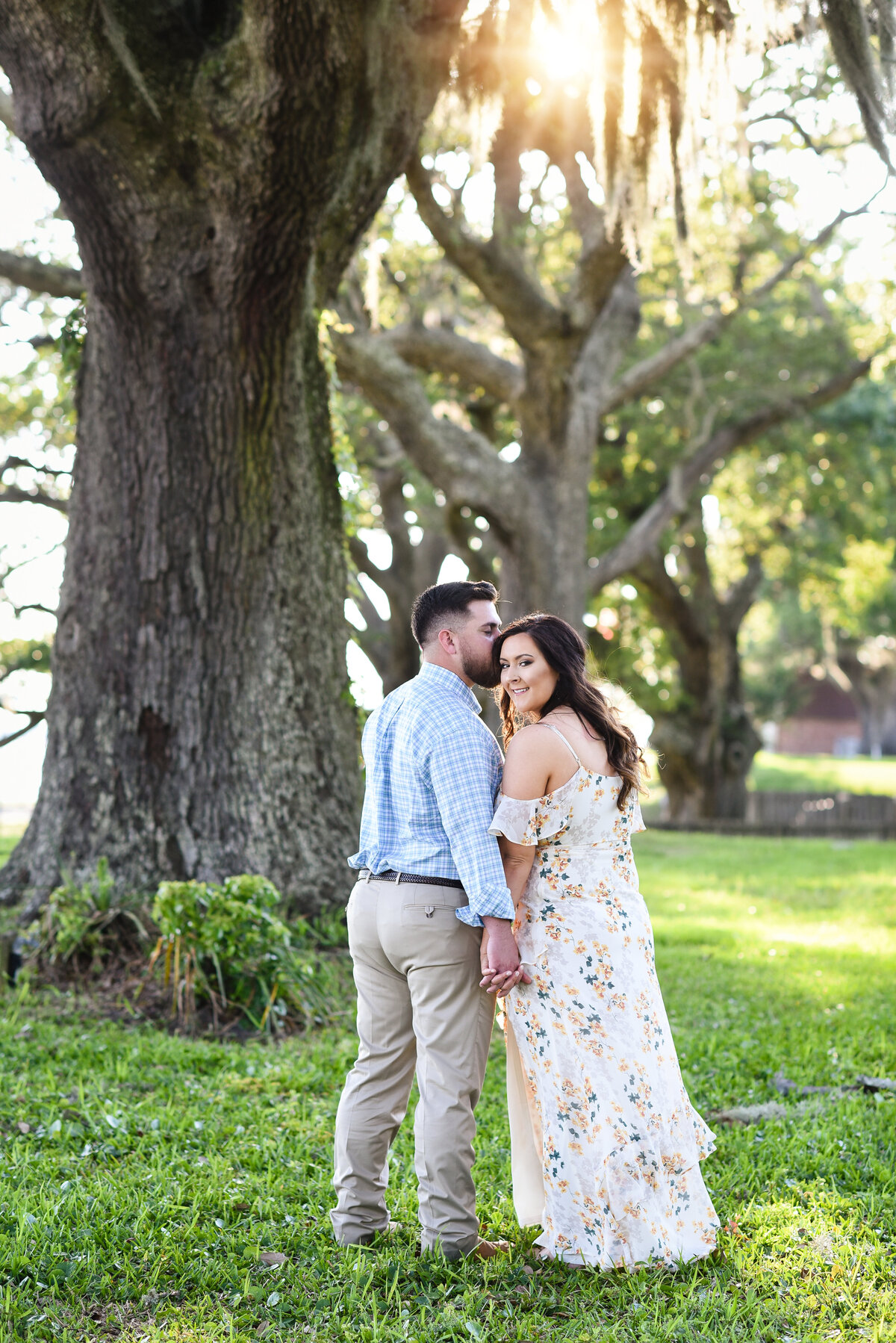 Beautiful Mississippi Engagement Photography: Couple walks away under Spanish moss as the sun sets in Ocean Springs, MS