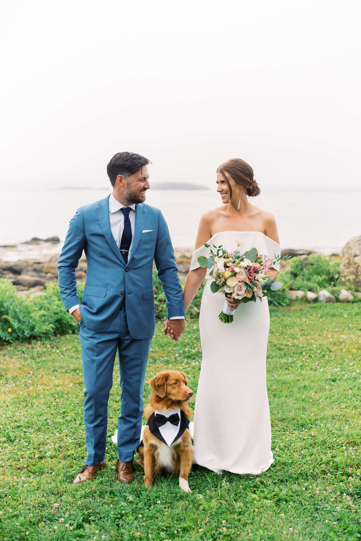 Bride and groom holding hands with dog beside them at Oceanstone Resort Wedding in Nova Scotia
