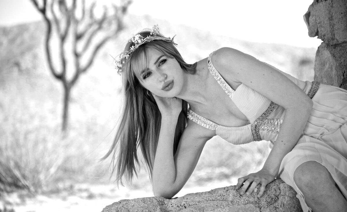 Country musician portrait black and white Kendall Rucks elbow leaning down against stone wall desert background