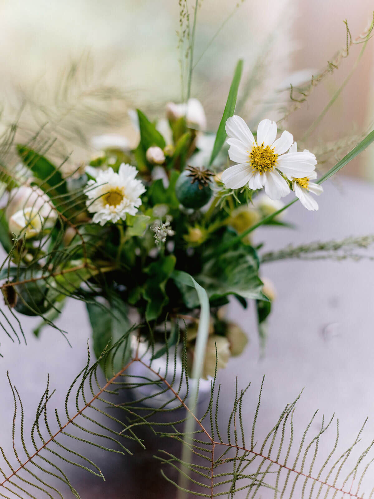 Pretty, small white flowers with greens in a vase in Montage at Palmetto Bluff. Destination wedding image by Jenny Fu Studio