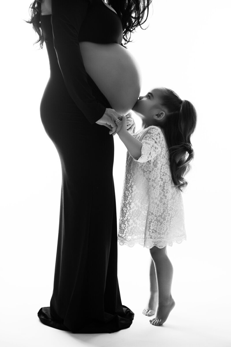 Little girl kissing mom's pregnant belly, by maternity photographer nj
