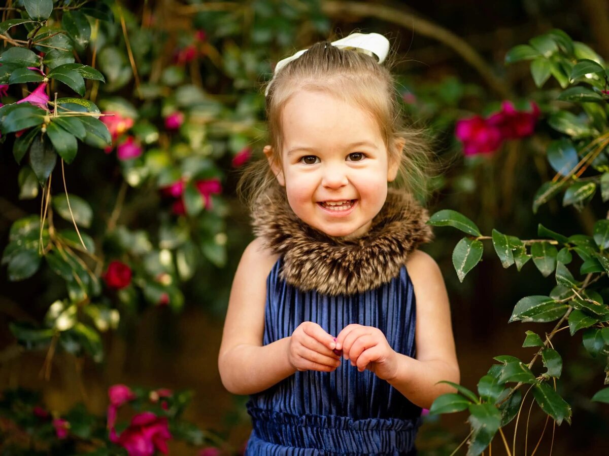A small child in a dress smiling.