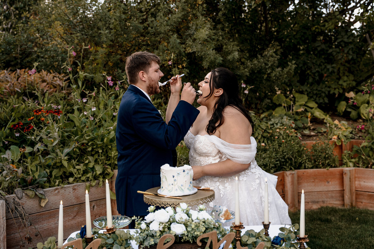 The bride and groom feed each other bites of cake at The Barn on Hinman in Cashmere, Washington.