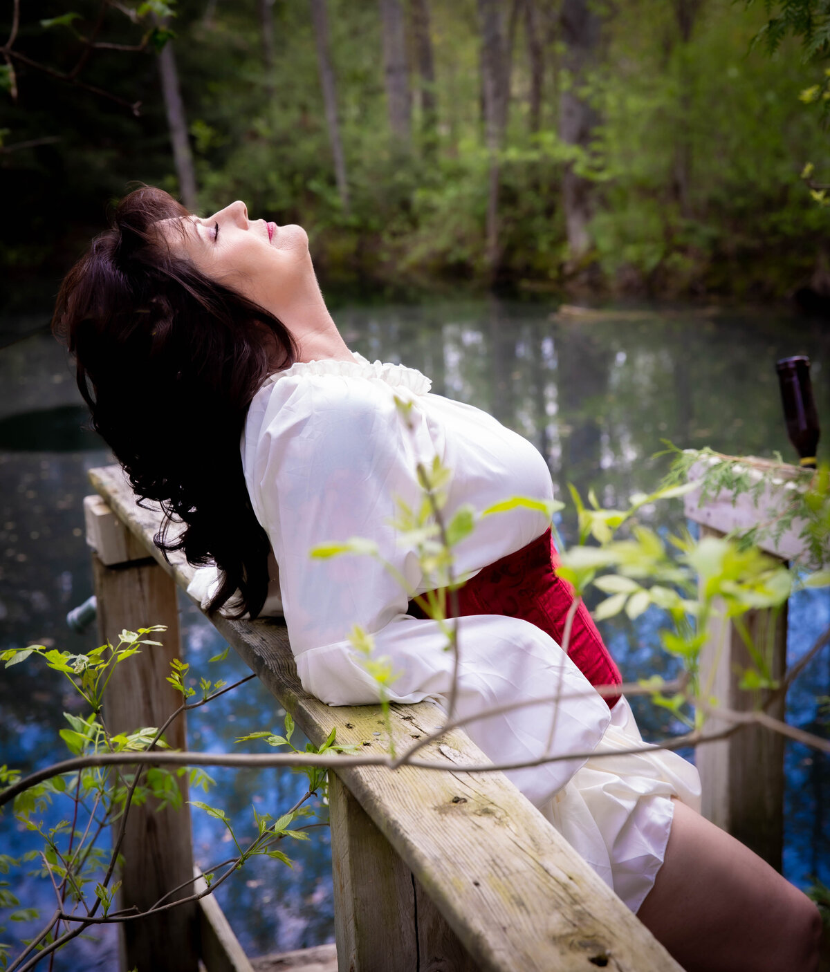 goddess studio woman laid back sun on face water red waist corset nature