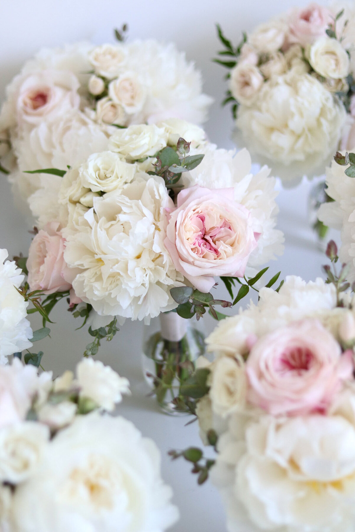 Blush and white peonies and garden roses bridesmaid bouquets for a wedding.