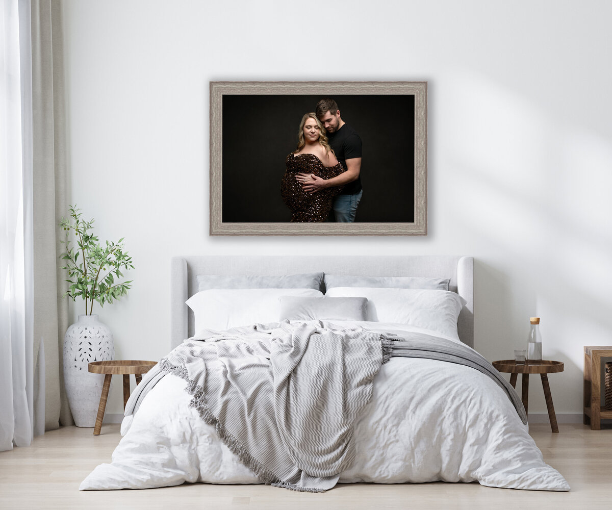Fine art Maternity portrait hanging above a bed in the bedroom.