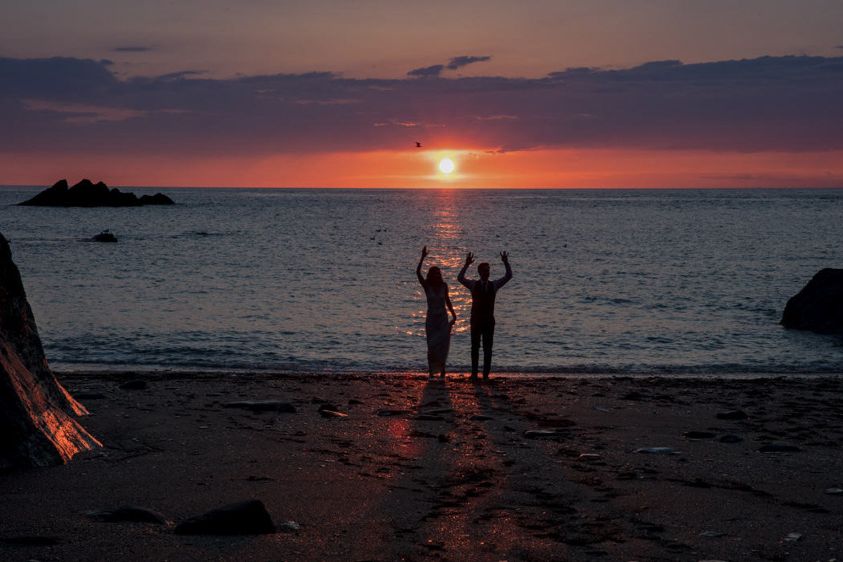 Couple waving at sunset Tunnels Beaches Wedding