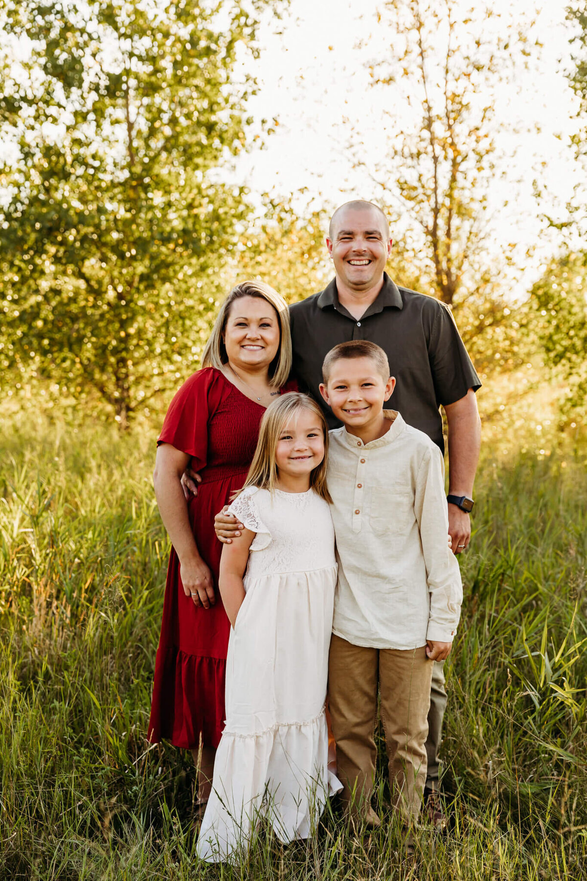 husband and wife smiling with their children  for family photos .