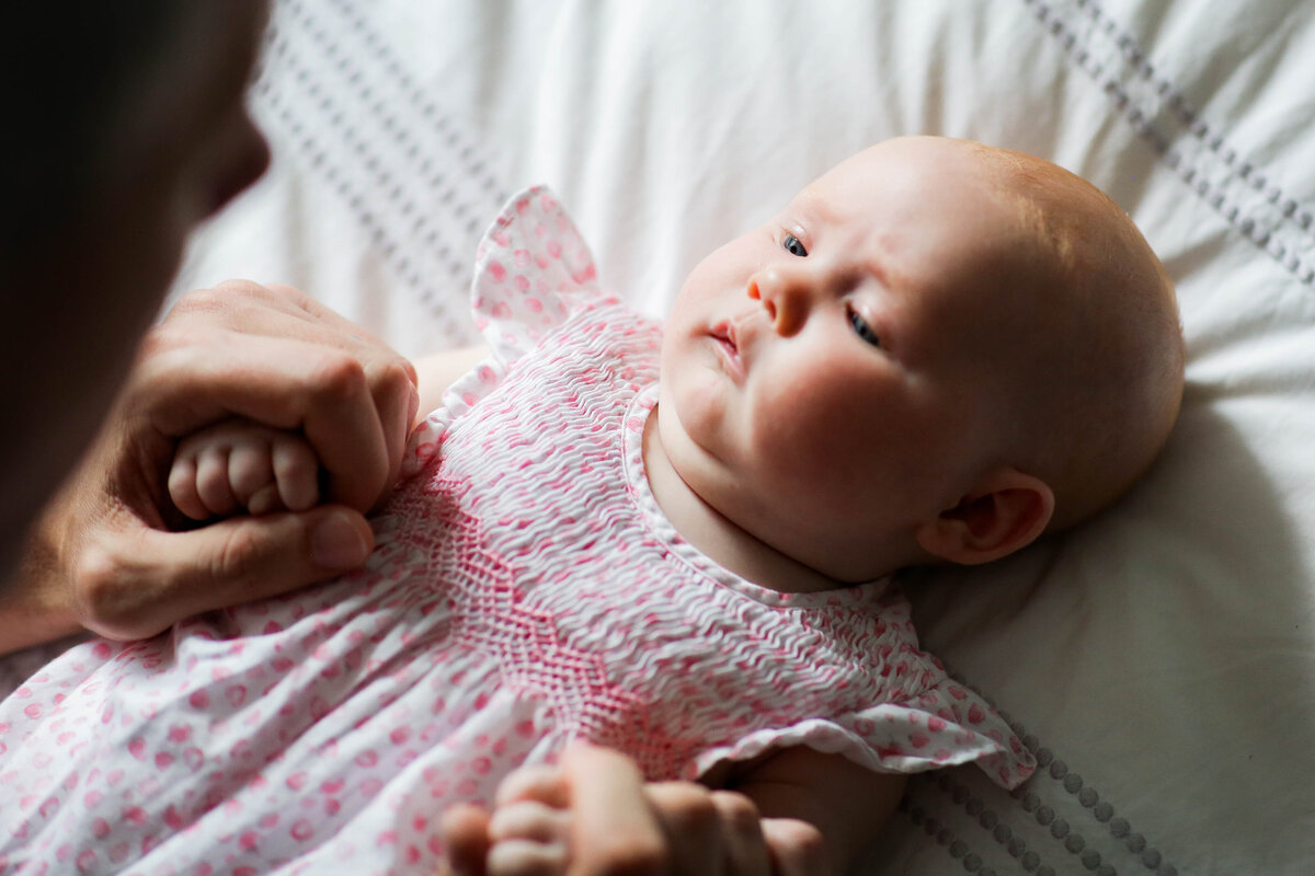 A little baby girl in Daddy's hands, captured by the renowned baby photographer Vanessa Keevil.