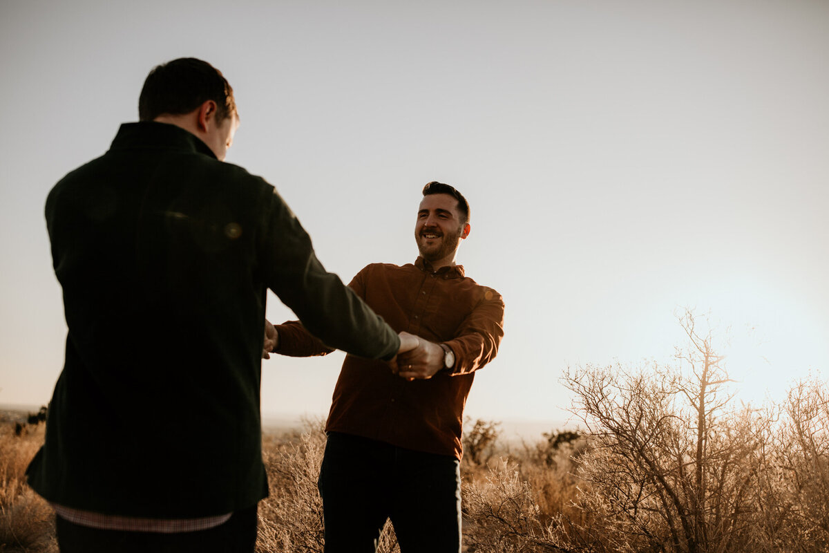 gay couple holding hands and spinning in New Mexico