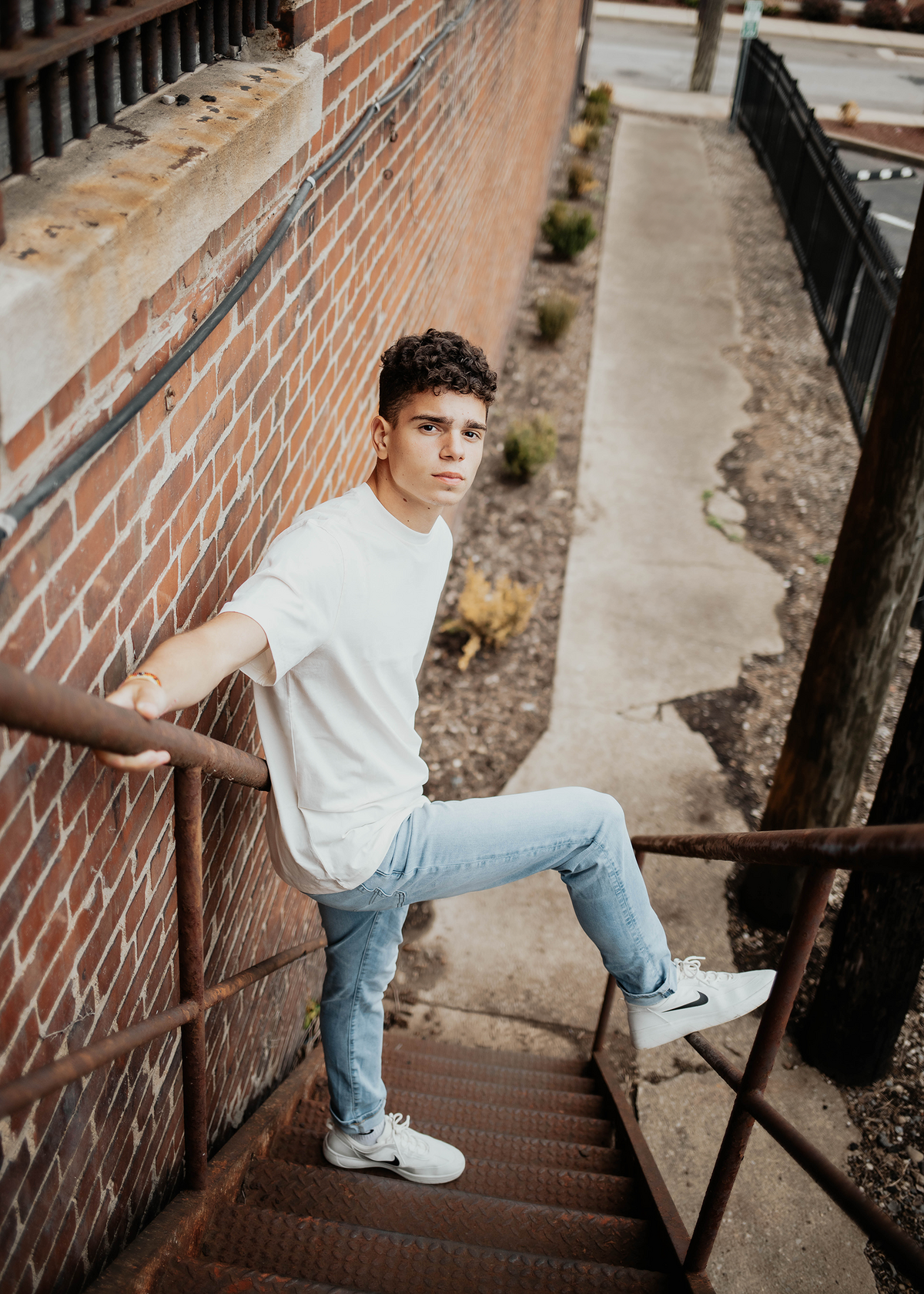 Senior boy looking up on rustic urban steps