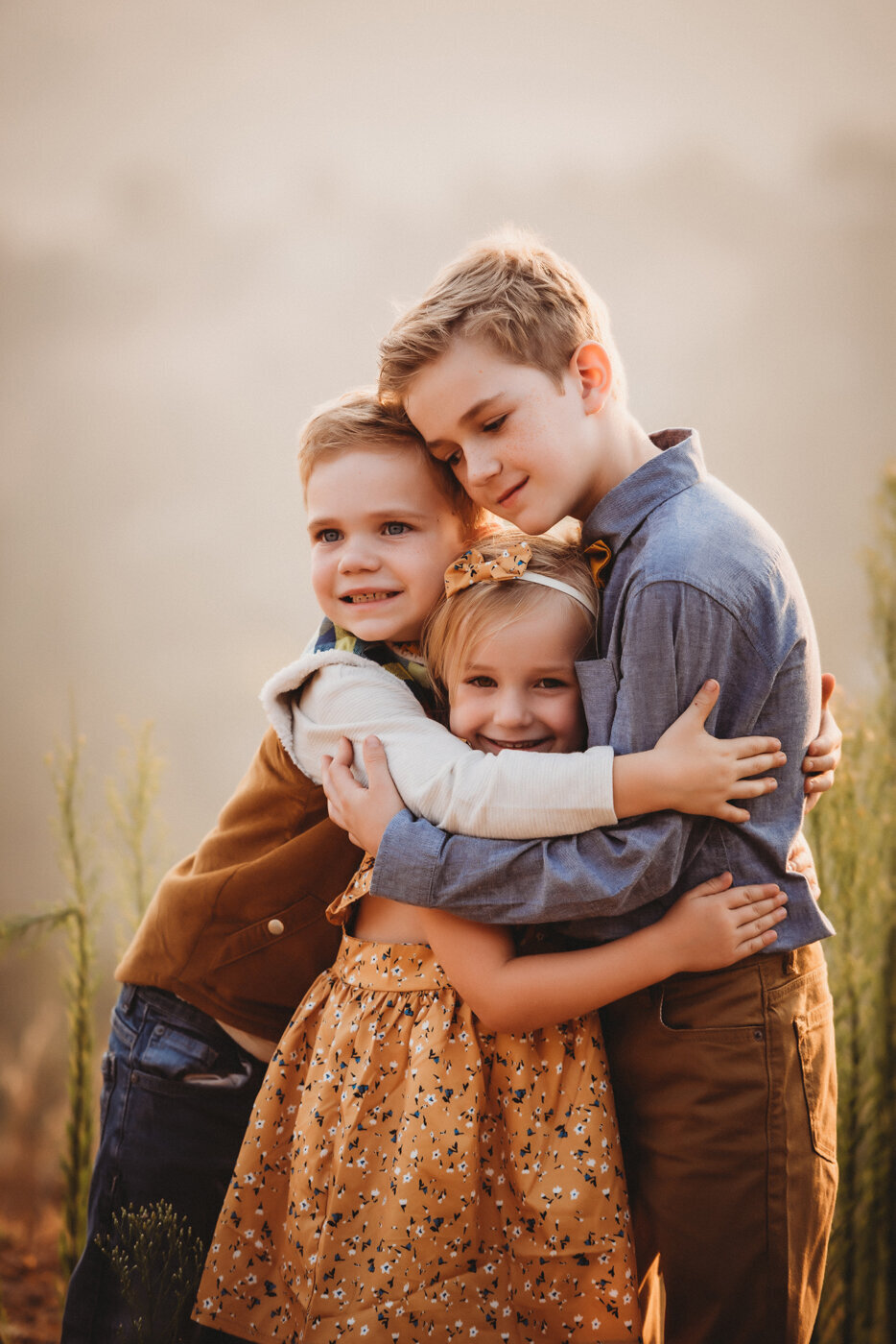 Three siblings share a hug