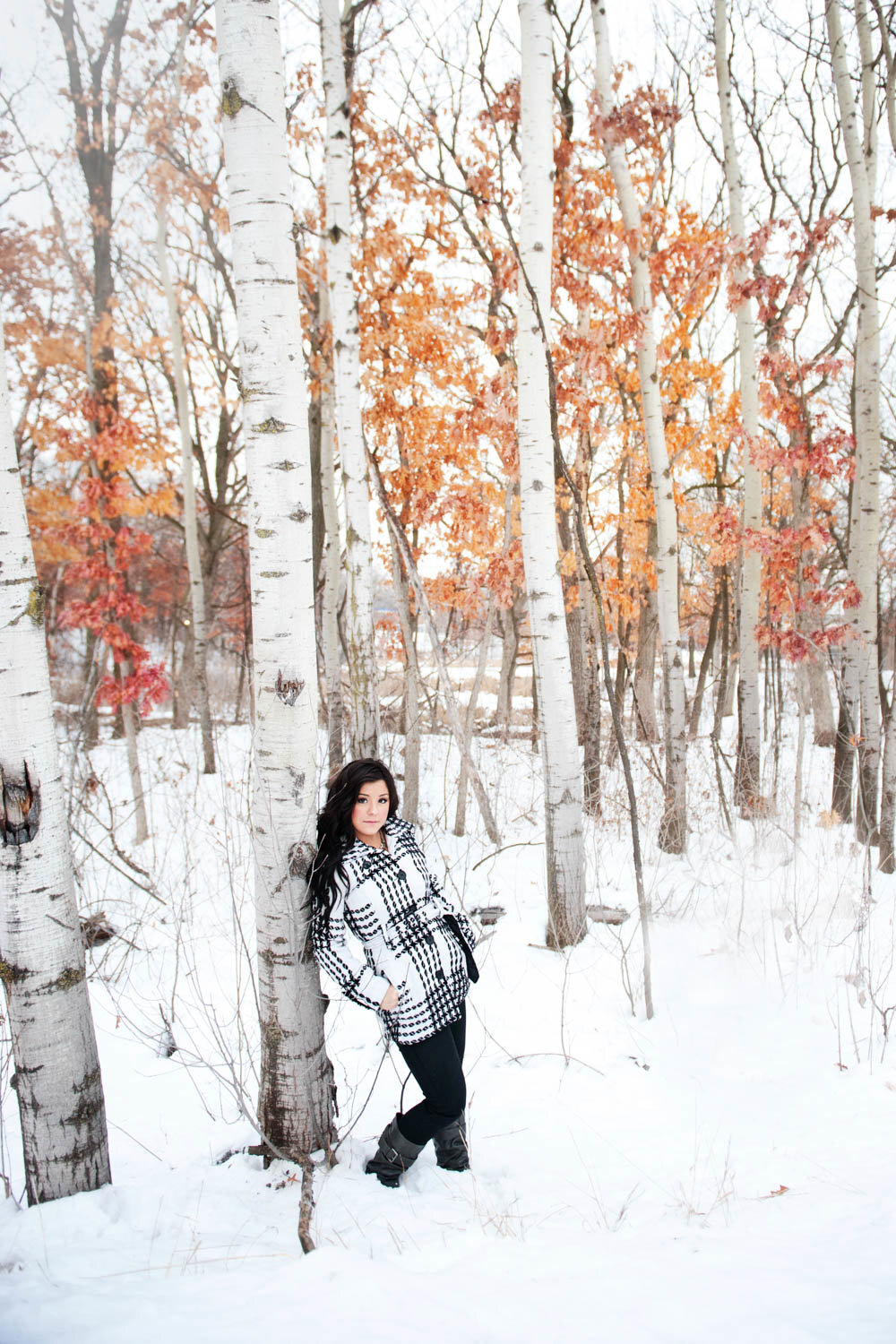 senior photo of girl in black and white jacket in the snow with birch trees