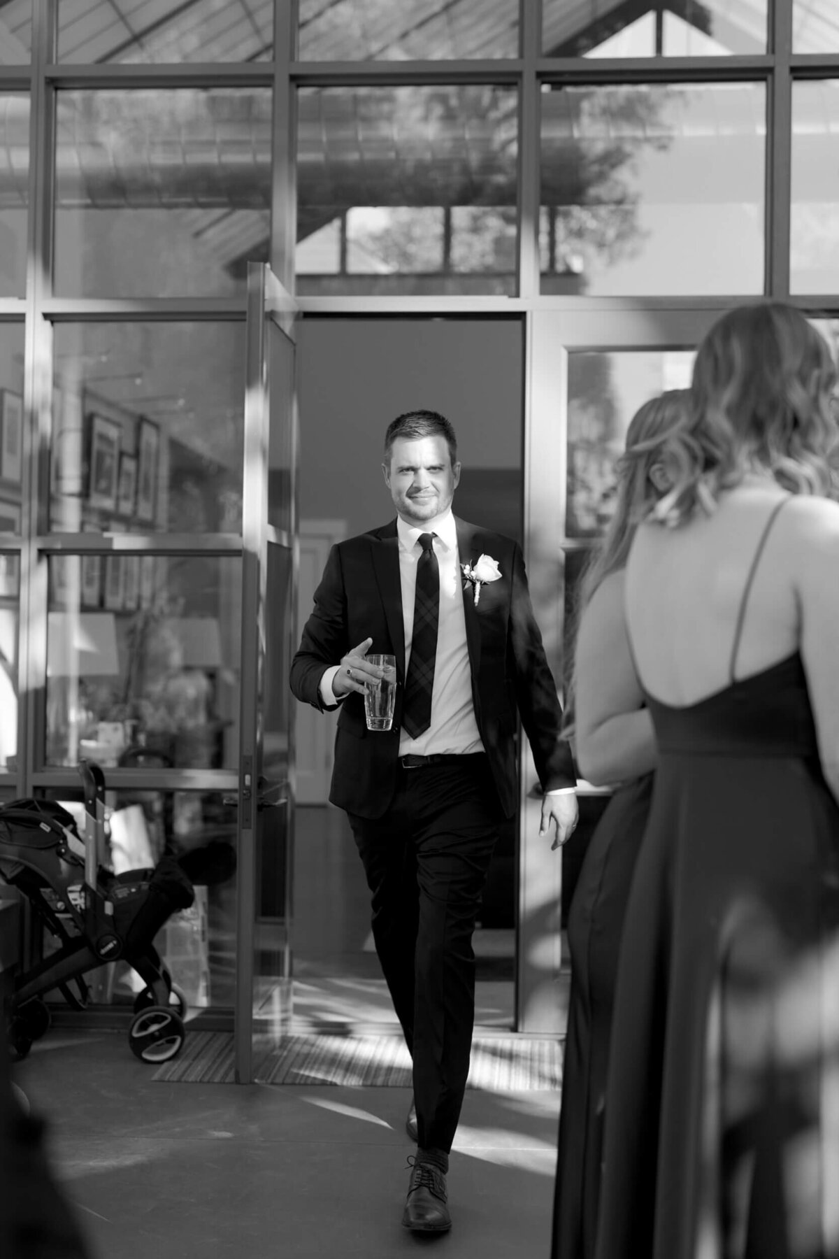 Bridegroom grabs a drink at his wedding and breezes past the bridesmaids.