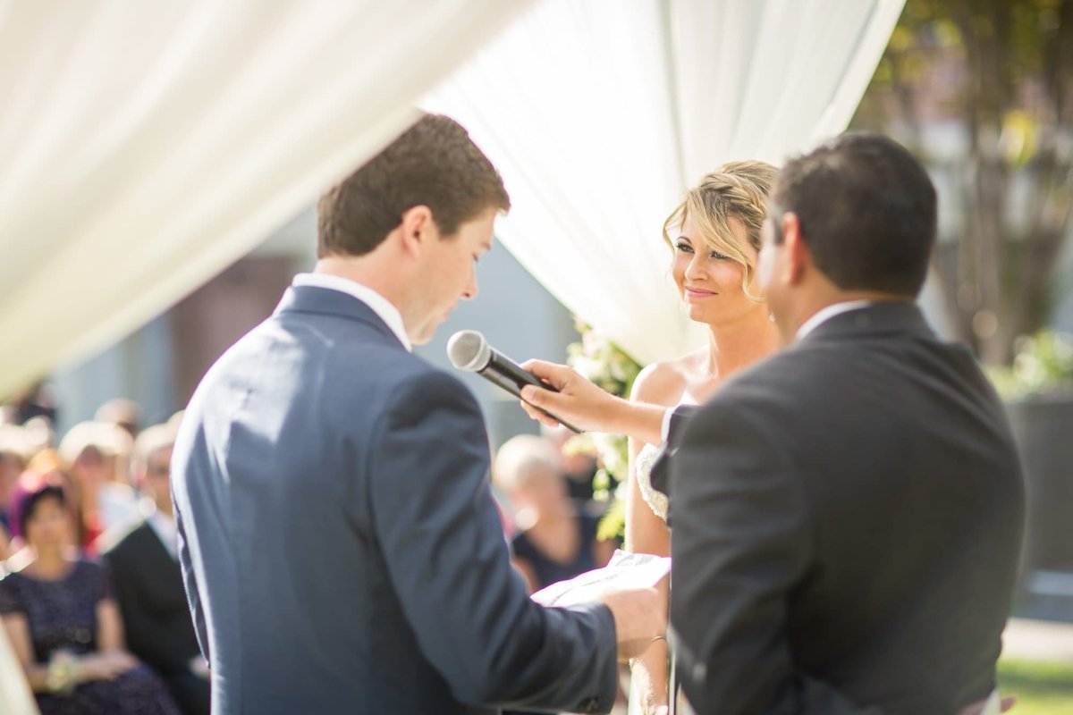 Bride watches her Groom as he reads his vows to her