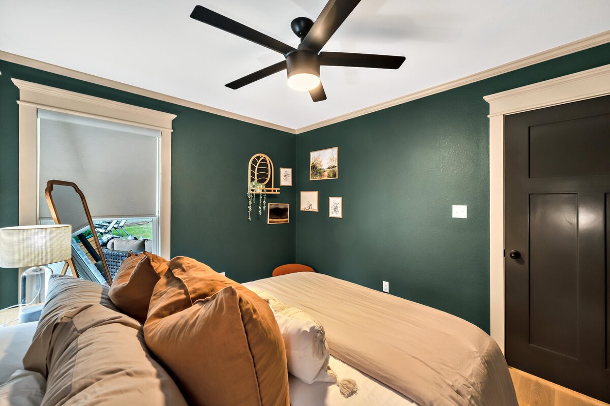 Bedroom with beautiful luxury bedding and full length mirror in this three-bedroom, three-bathroom vacation rental home with free wifi, outdoor theater, hot tub, propane grill and private yard in Waco, TX.