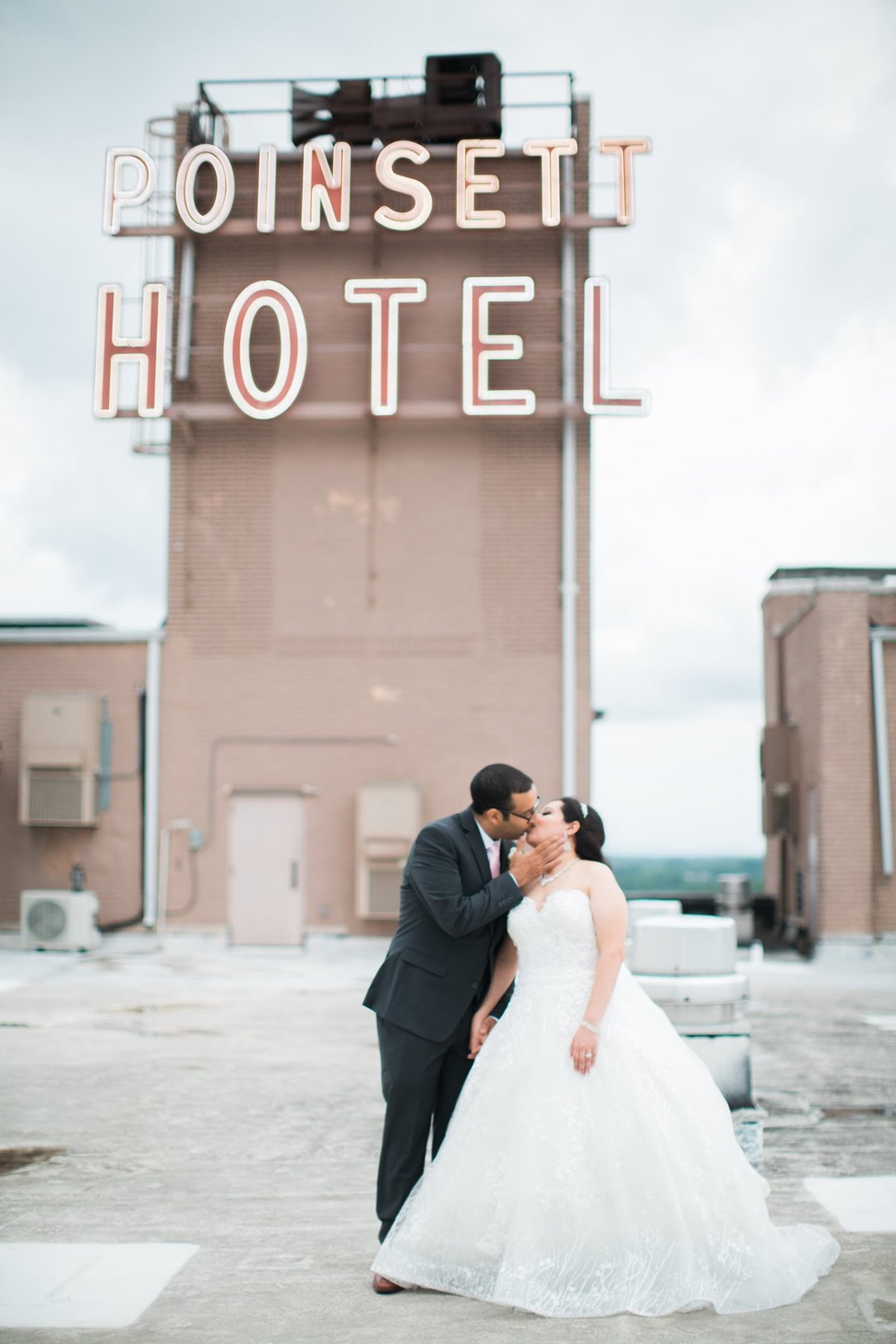 Wedding Photographer, couple kissing beneath a hotel sign