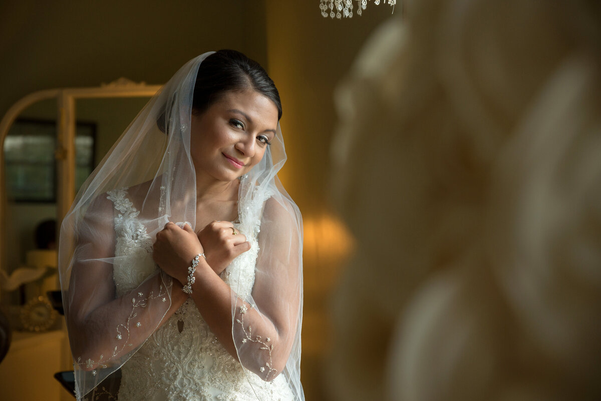 Bride holding wedding veil.