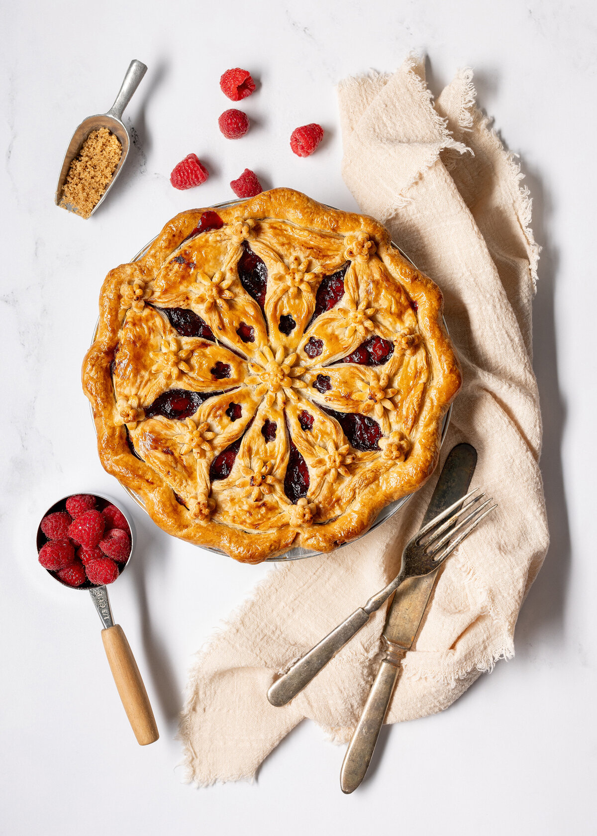 A pie with raspberries around it