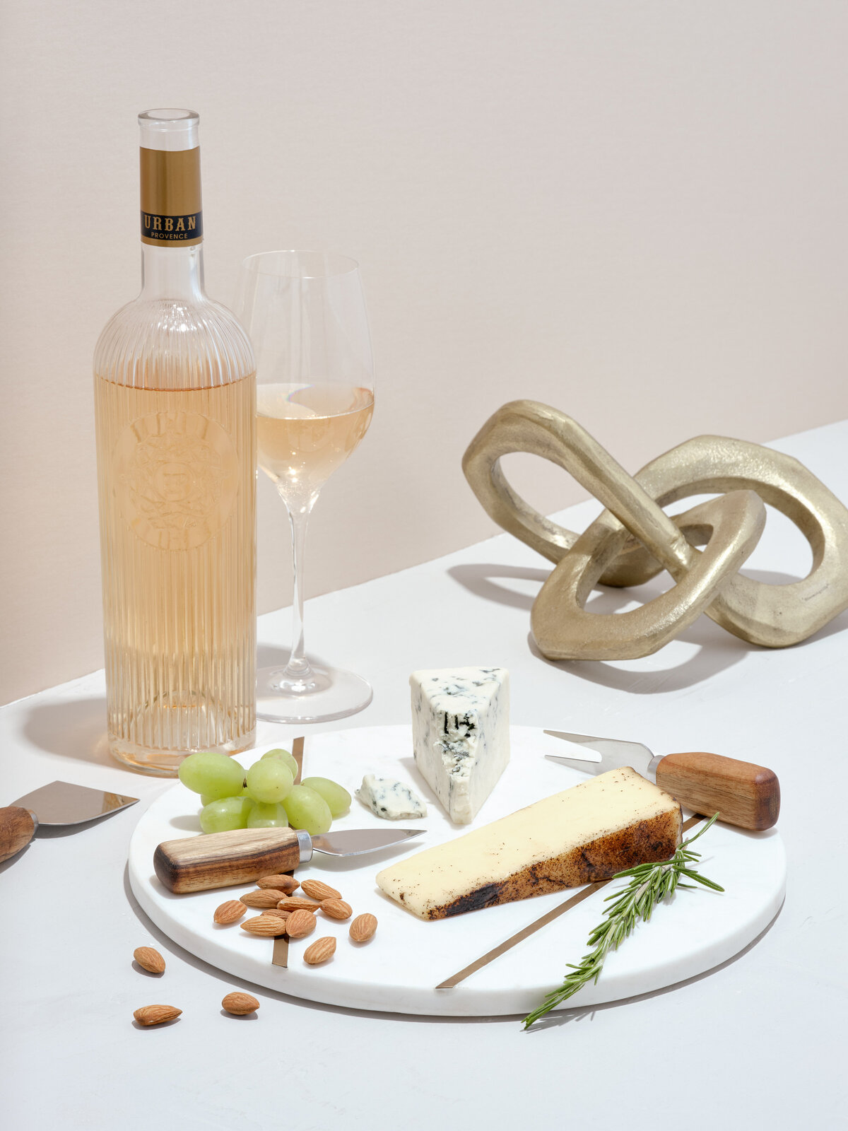 A charcuterie board with a bottle and glass of wine